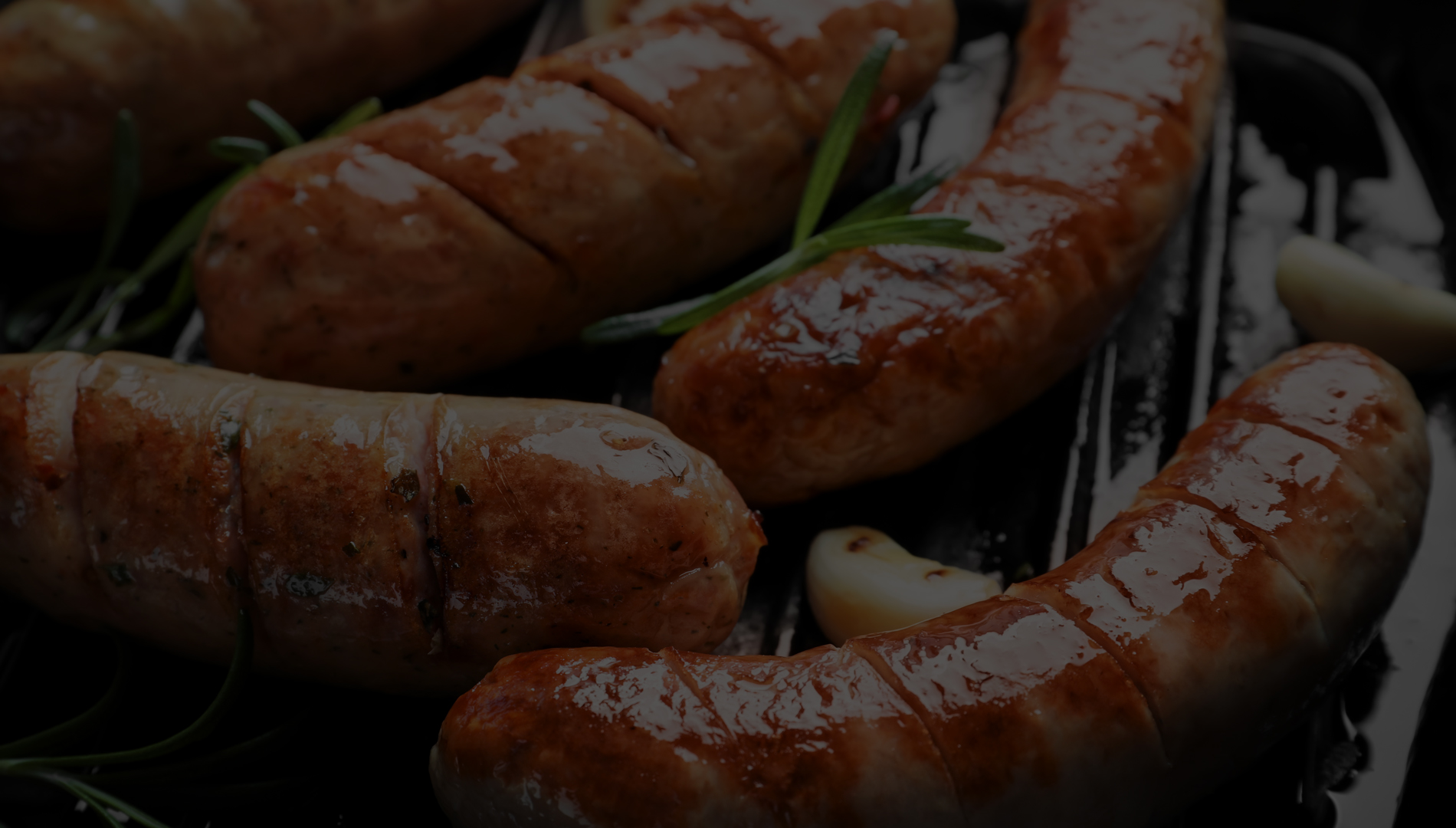 Perfectly grilled sausages with fresh rosemary and garlic.