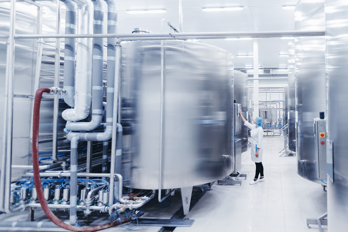A clean, modern food production hall with large stainless steel vats.
